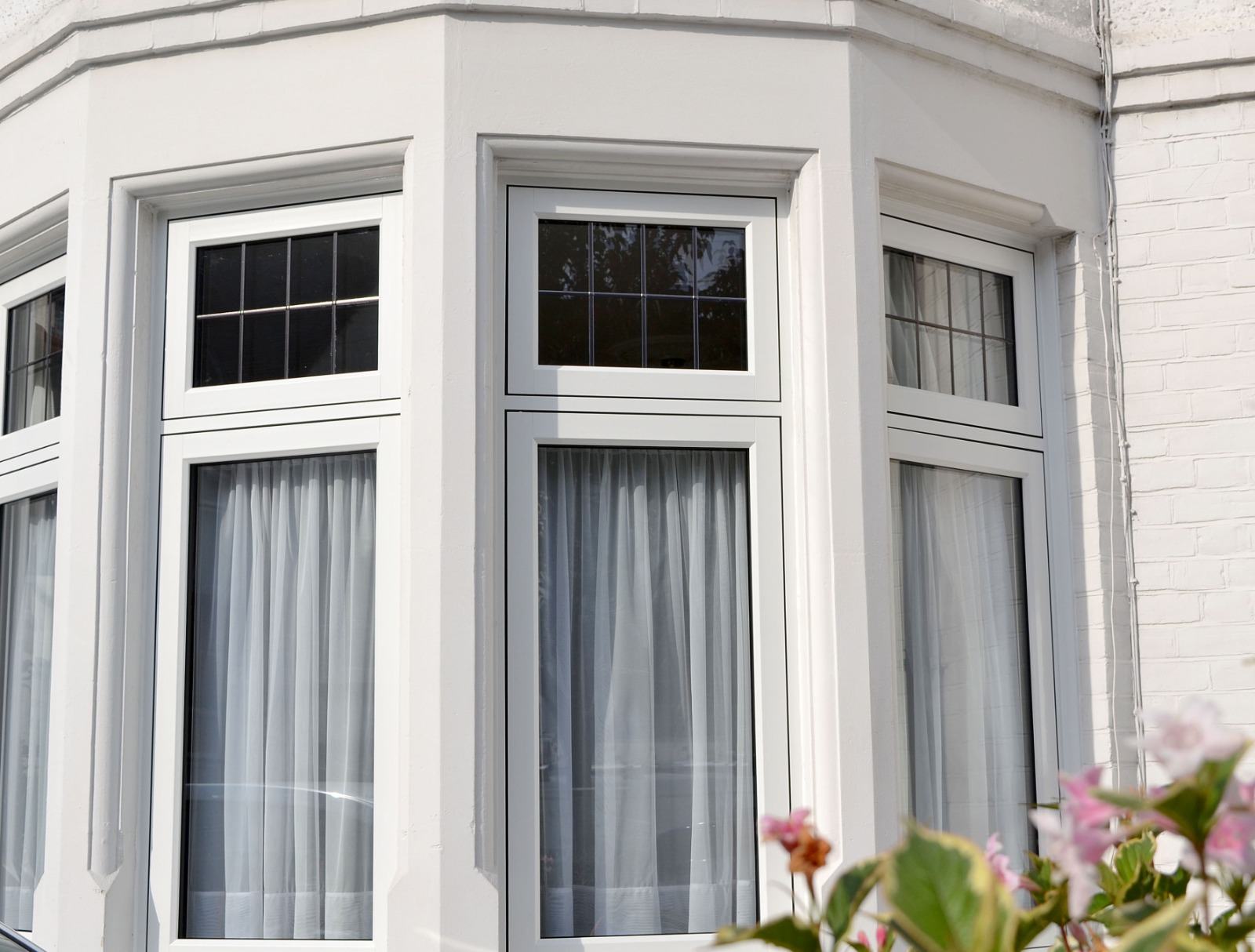 Interior view of a white uPVC bay window with slim glazing bars in a period reception room